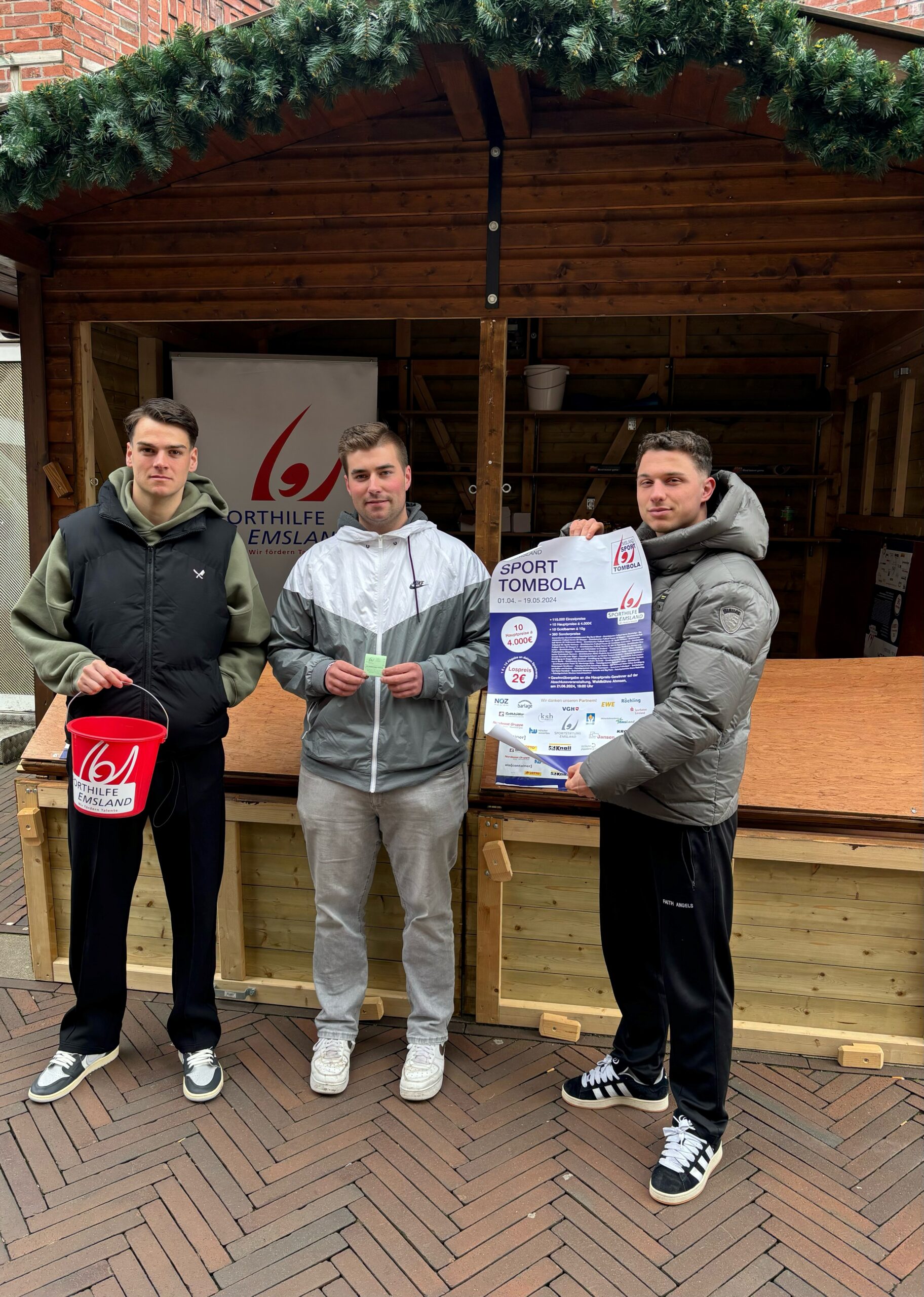 SVM-Kapitän Jonas Fedl (links) und Teamkollege Tobias Mißner (rechts) verkauften in der Meppener Innenstadt fleißig Lose und gratulierten Fabian (Bildmitte) zum Gewinn. Foto: Patrick Vehring